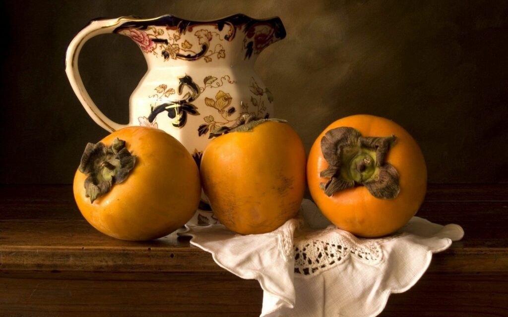 Rustic Wallpaper: Elegant Ripe Persimmons on Wooden Surface