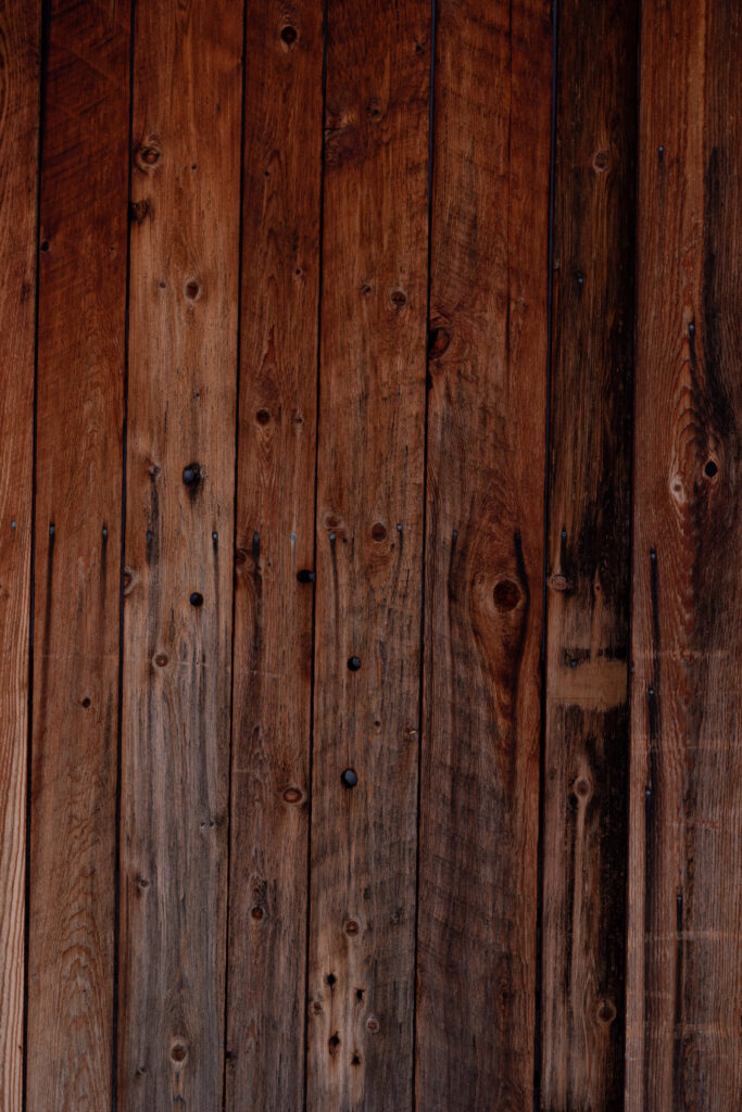 Earth-toned Elegance: Captivating Vertical Alignment of Richly Textured Dark Wood Wall Panels Wallpaper
