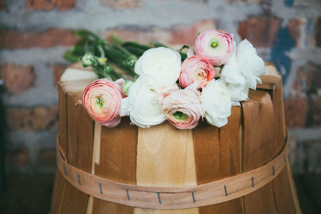 Rustic Barrel with Soft Pink Peonies on Textured Brick Wallpaper