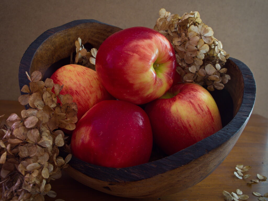 Rustic Wooden Bowl of Red Apples & Dried Hydrangeas Wallpaper