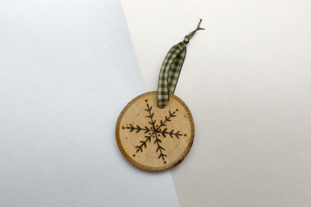 Rustic Wooden Snowflake Ornament with Green Plaid Ribbon Background Wallpaper