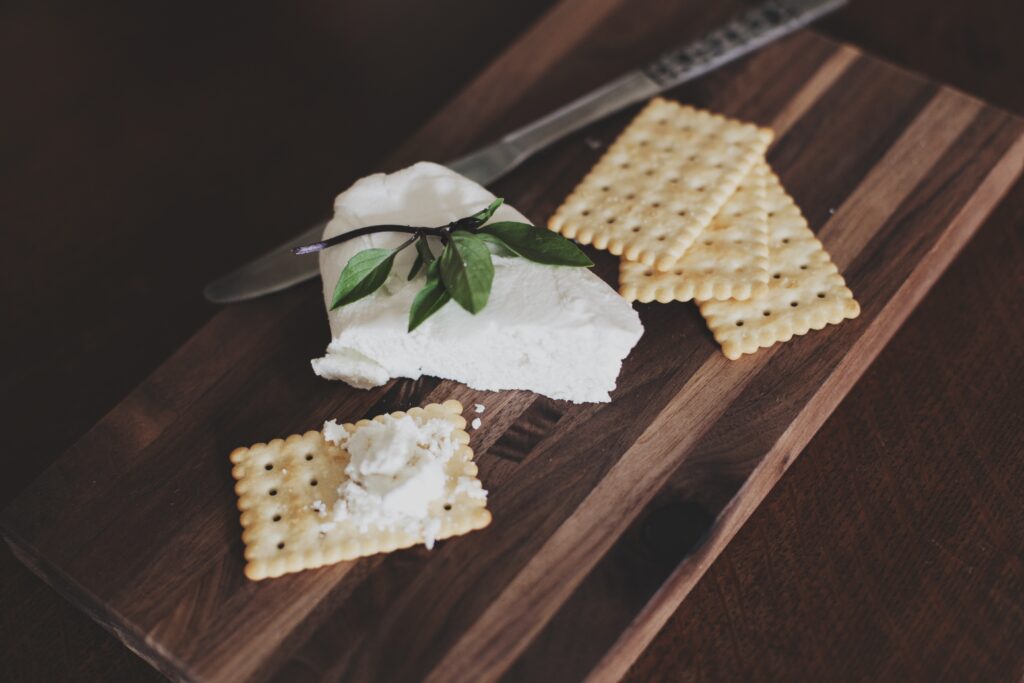 Rustic Cutting Board with Crackers, Cheese & Fresh Herbs Wallpaper