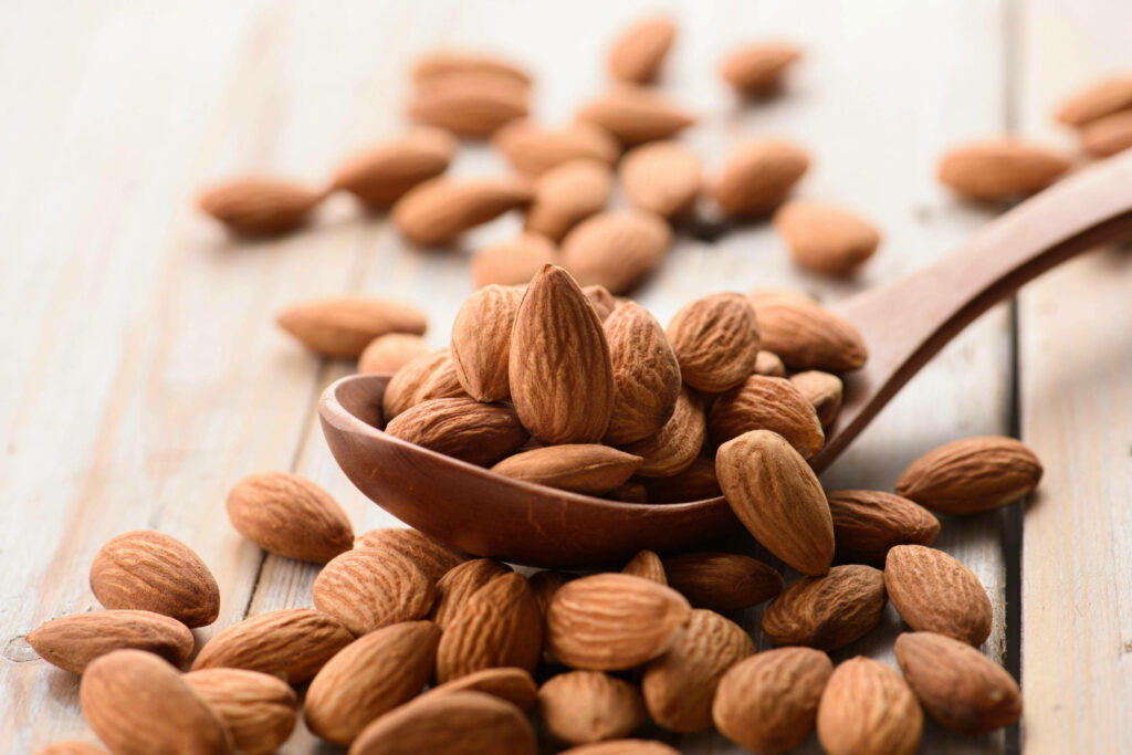 Natural Almonds on Wooden Spoon - Rustic Wallpaper Background