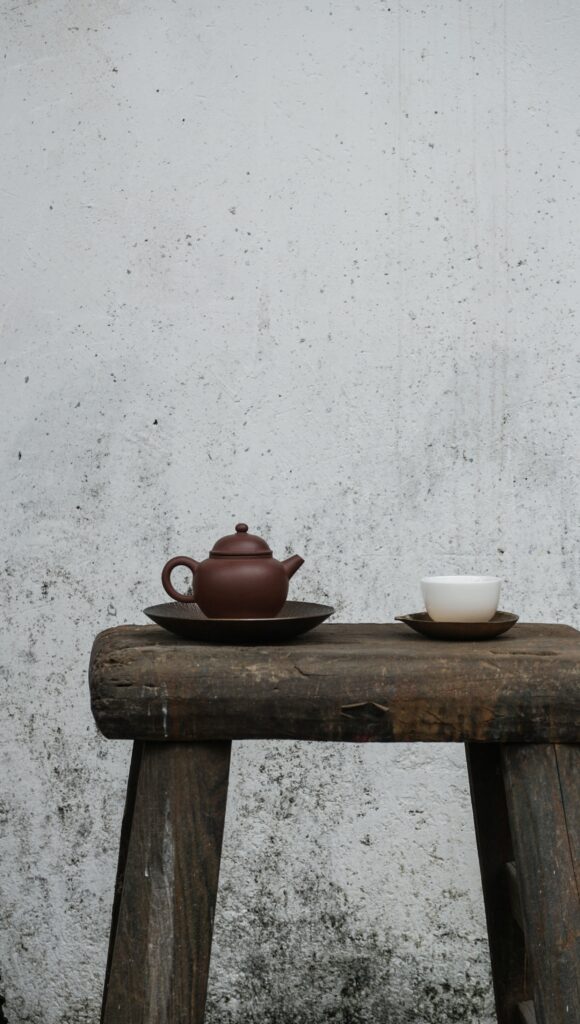 Serene Tea Scene: Rustic Wooden Table with Kettle & Cup Wallpaper