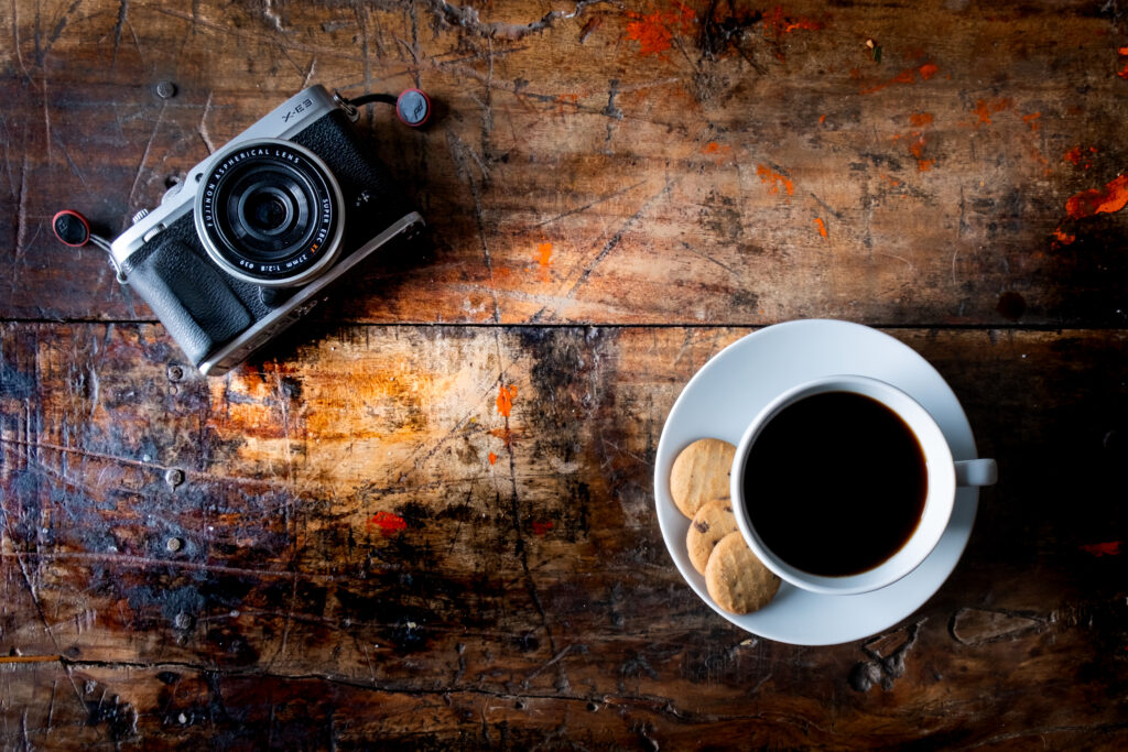 Rustic Wooden Table with Coffee, Cookies, and Vintage Camera Wallpaper