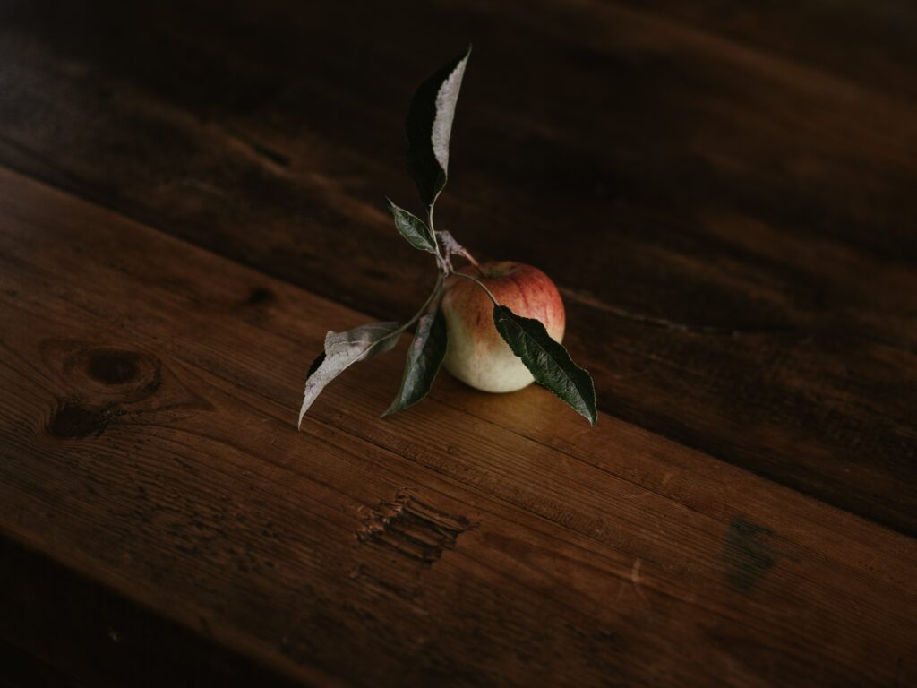 Rustic Wooden Table with Red Apple & Green Leaves Wallpaper
