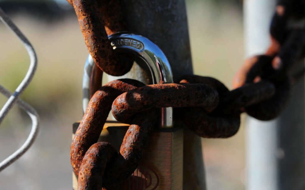 Rusty Chain and Lock on Mesh Fence: Textured Metal Wallpaper