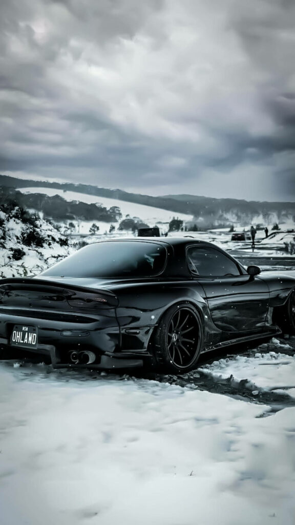 Captivating Rx7: A Snowy Street Encounter with Mazda's Sleek Black Beauty Wallpaper