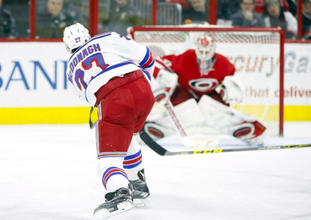 Ryan McDonagh New York Rangers powerful shot against Carolina Hurricanes goalie intense hockey match Wallpaper