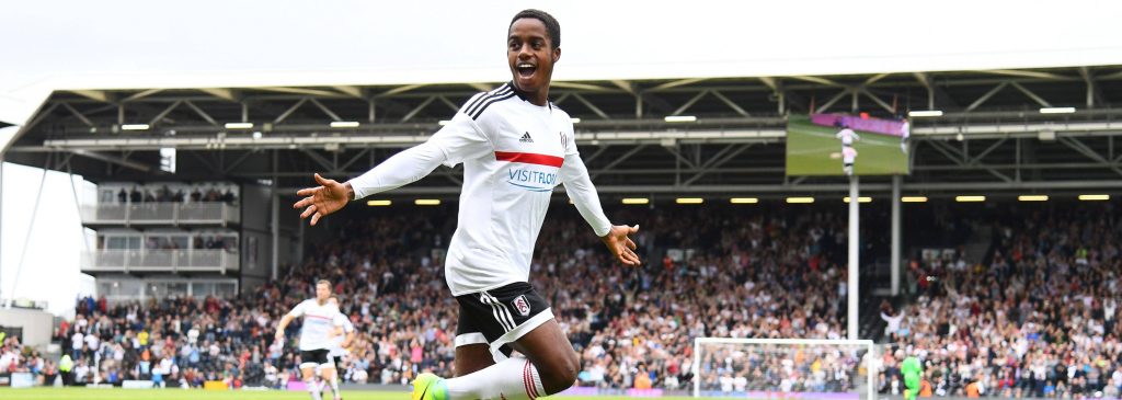 Ryan Sessegnon celebrating goal in white Fulham FC kit with crowded stadium background wallpaper