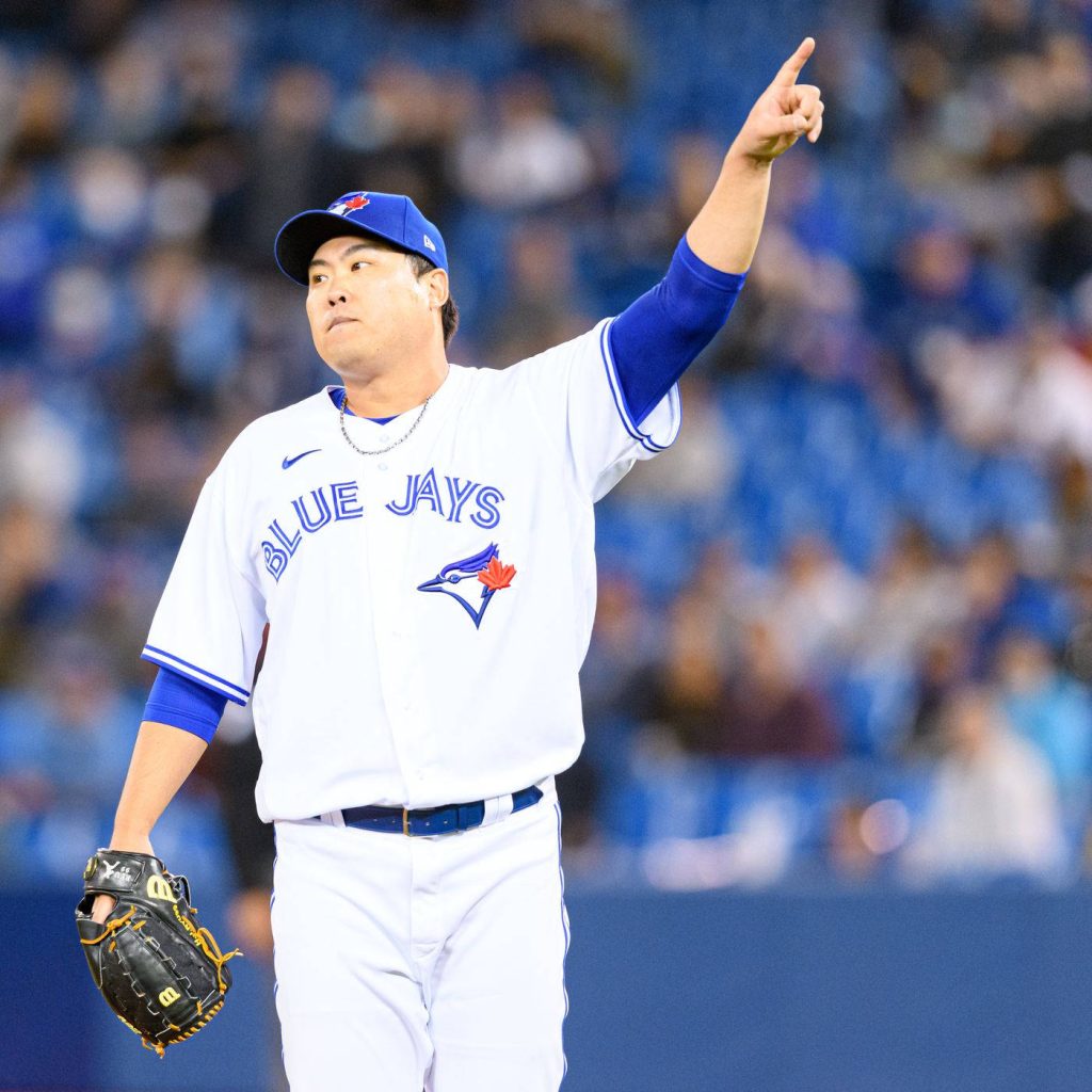 MLB pitcher Ryu Hyun-jin in Toronto Blue Jays uniform points skyward in vibrant stadium wallpaper