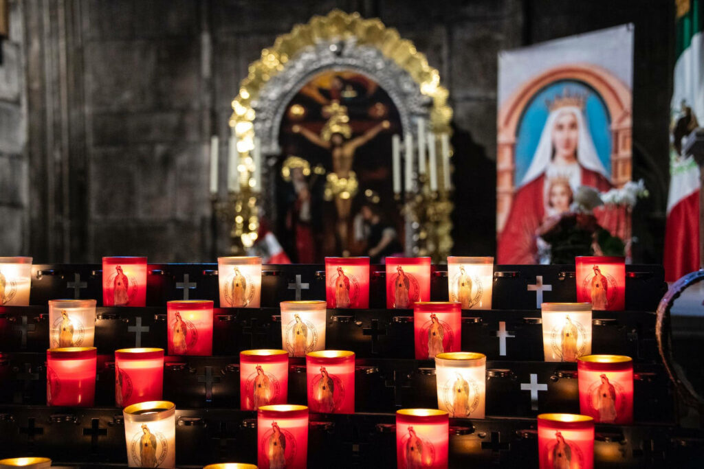 Sacred Illumination: Crossbearing Jesus and Marian Veneration amidst Lit Church Candles Wallpaper