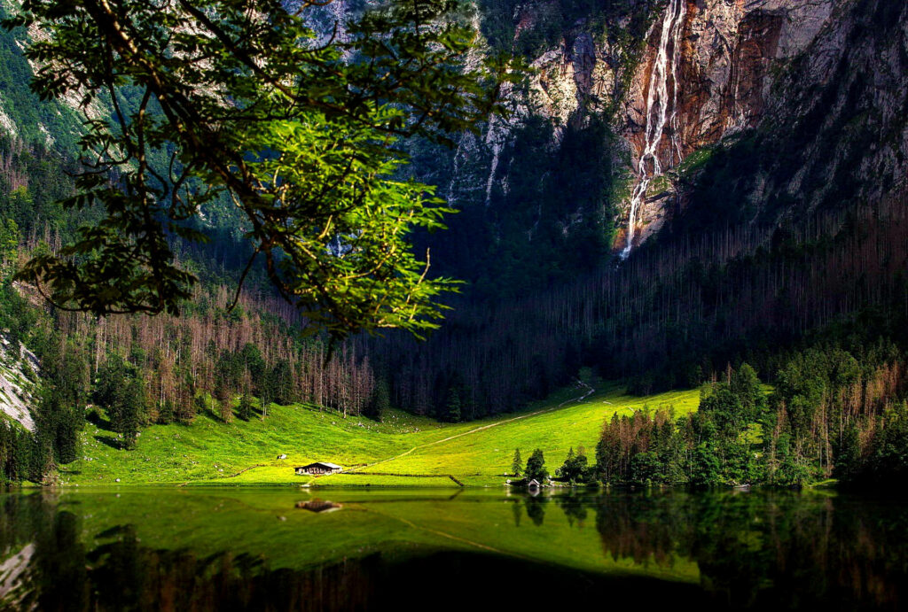 Enchanting Mountain Scenery: Majestic Peaks Embrace a Tranquil Emerald Meadow in Crystal Clarity Wallpaper