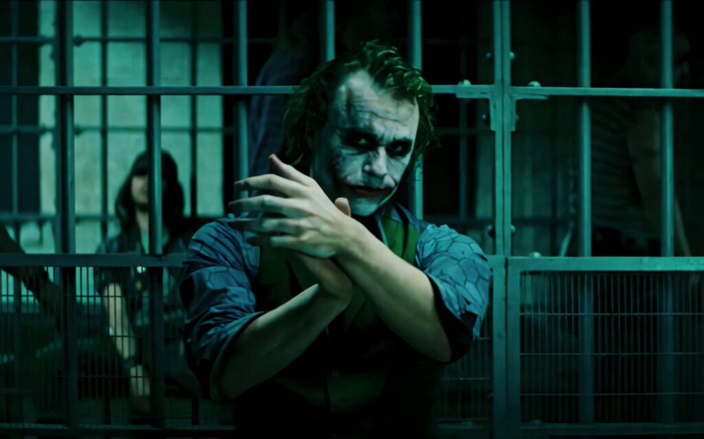 Sad Joker in Dim Prison Cell: Intense Haunting Wallpaper Background