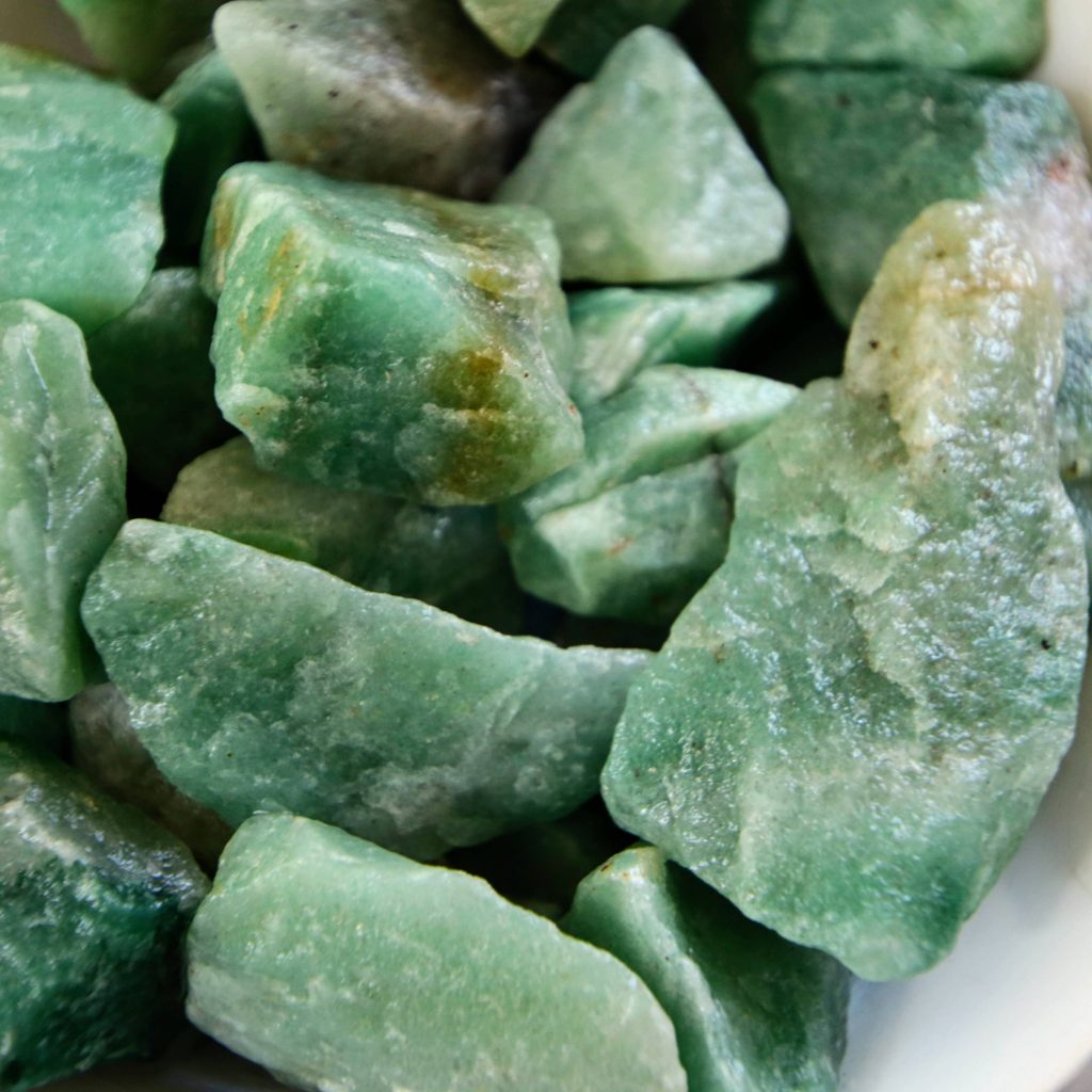 Macro view of raw sage green quartz crystals with rough textures and natural lighting background Wallpaper