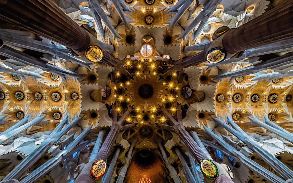 Sagrada Familia ceiling with intricate branching columns and golden geometric patterns interior Wallpaper