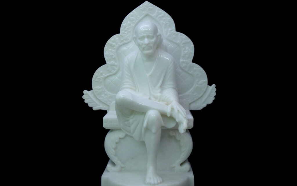 Sai Baba white marble statue seated in serene pose on black background spiritual sculpture Wallpaper