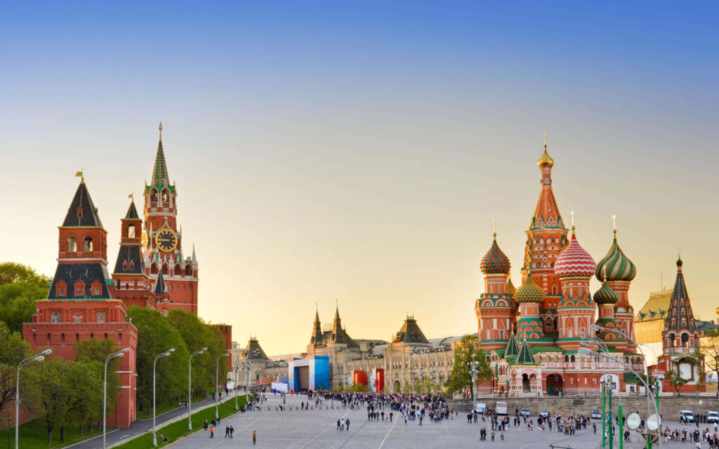 Vibrant Saint Basil's Cathedral domes in Moscow Red Square at evening with lively city crowd Wallpaper