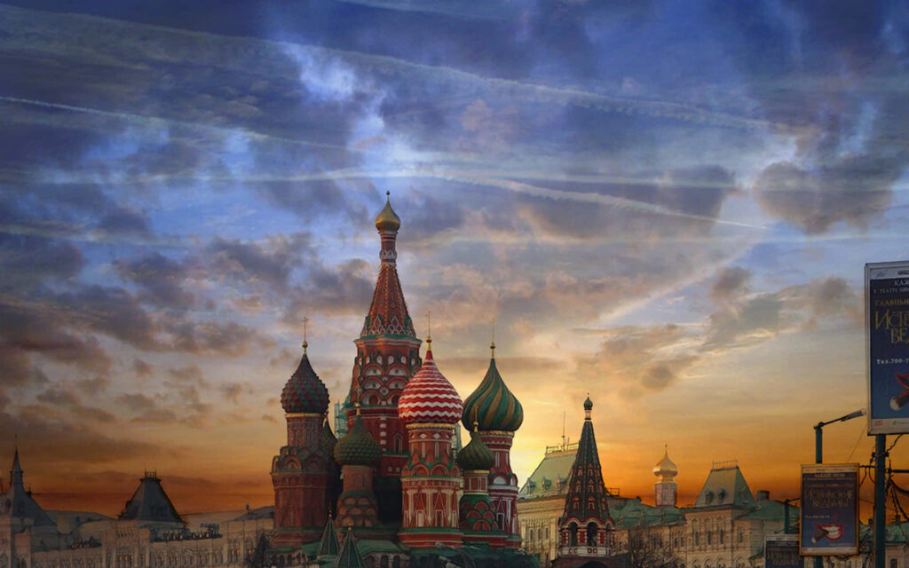 Saint Basils Cathedral in Moscow with colorful domes glowing under a vibrant sunset sky wallpaper