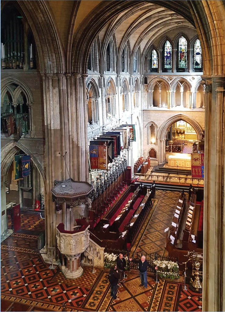High-angle view of Saint Patrick’s Cathedral Gothic interior with choir stalls pulpit and tiled floor Wallpaper