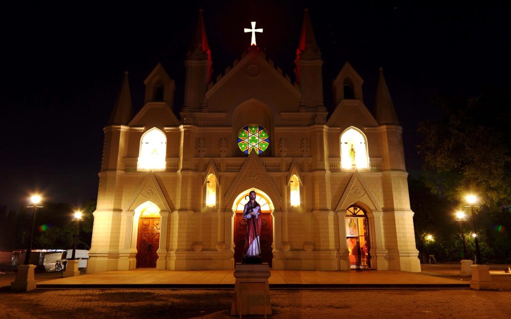 Saint Patrick's Cathedral Pune night Neo-Gothic facade glowing stained glass window statue Wallpaper