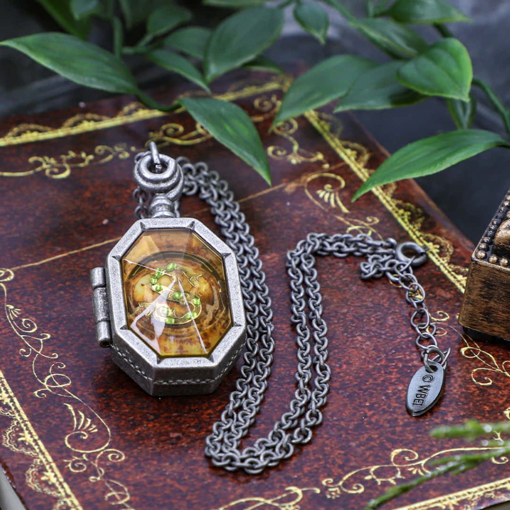 Salazar Slytherin’s Locket on antique book with lush foliage dark magic Harry Potter wallpaper