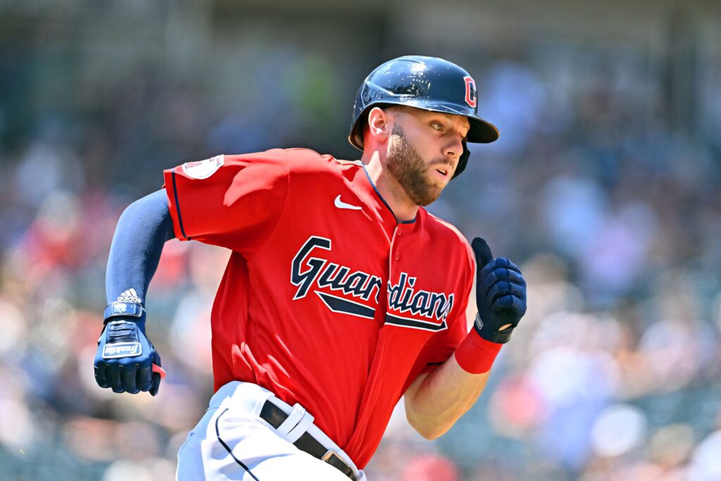 Sam Hentges Cleveland Guardians pitching in red jersey and navy helmet with blurred stadium background Wallpaper