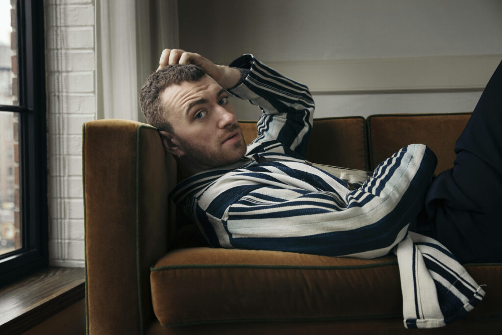 Sam Smith Relaxes on Cozy Couch – Stylish Wallpaper Background