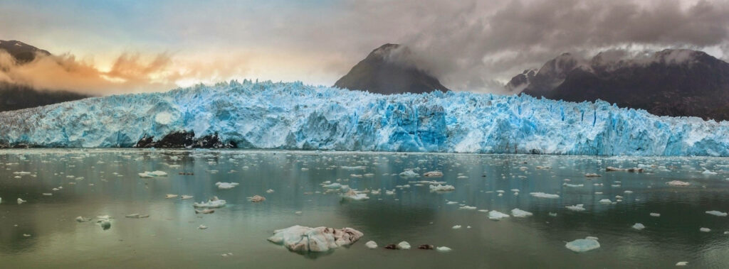 Icy glacier at San Rafael Lake Chile with serene waters and moody sky background wallpaper