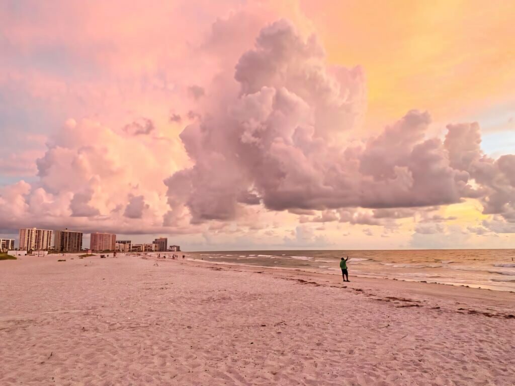 Sunset over Sand Key Florida beach with soft sand dramatic clouds and calm shoreline view Wallpaper