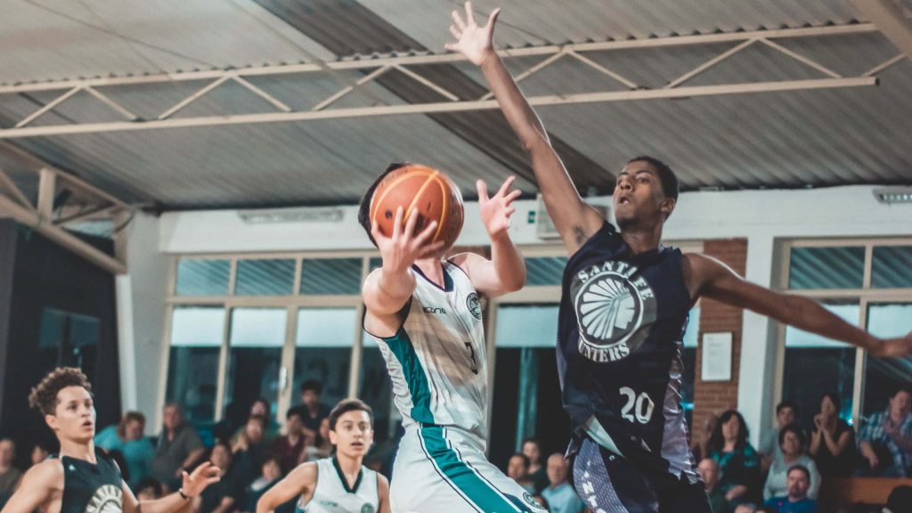 Santa Fe Hunters player No 20 blocks layup in intense indoor basketball game action wallpaper
