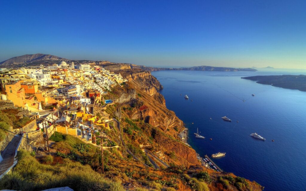 HDR wallpaper of Santorini Greece white houses on cliffs overlooking blue Aegean Sea with boats
