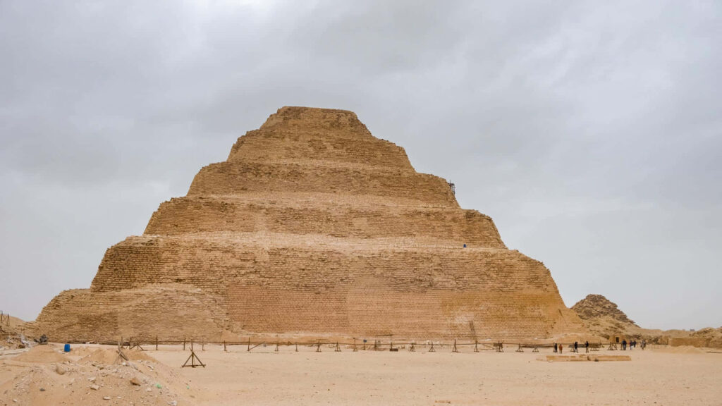 Saqqara Pyramid Egypt ancient limestone structure under dramatic gray sky wallpaper background