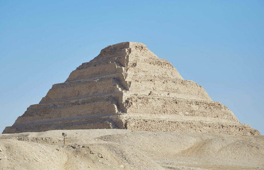 Ancient Saqqara Pyramid Egypt stepped stone blocks under clear blue sky wallpaper background