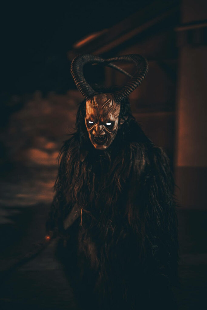 Spectral Visage: Unveiling the Dark Enigma of a Skull-faced Horned Entity Wallpaper