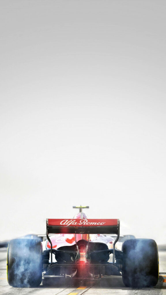 Rear view of Sauber C37 Formula 1 car with Alfa Romeo branding in action smoke wallpaper