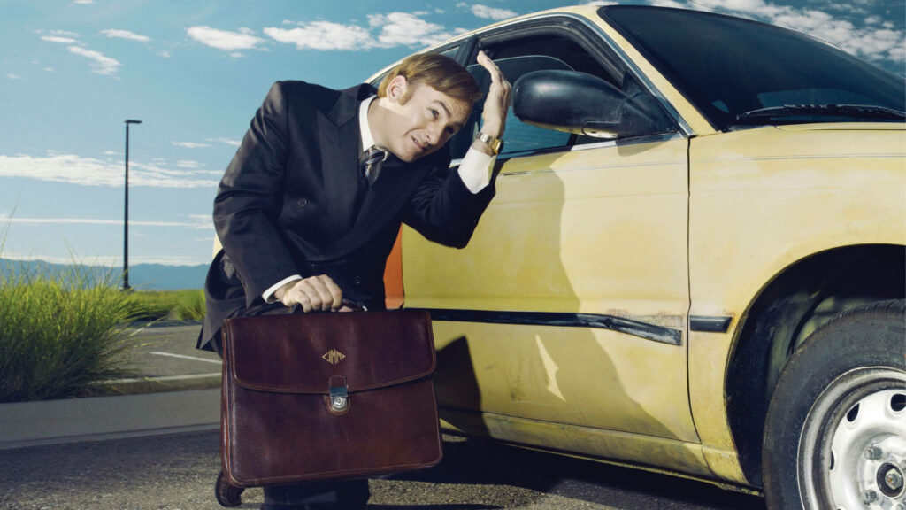 Saul Goodman leaning on yellow car looking into side mirror contemplative Better Call Saul wallpaper