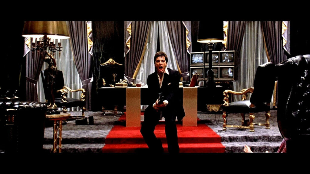 Scarface Tony Montana in lavish office holding weapon intense classic film wallpaper background