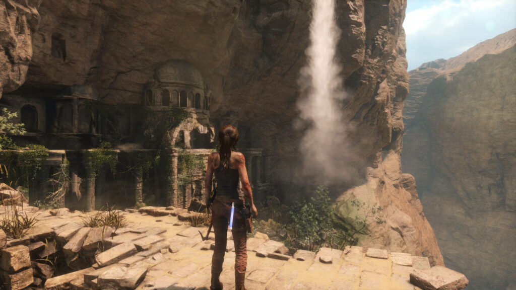 Survivor's Journey: The Battle-Scarred Lara Croft Amidst Ancient Ruins in Rise of the Tomb Raider Wallpaper
