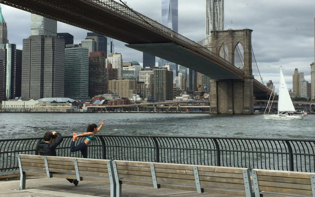 Scenic Brooklyn Bridge Wallpaper: Person Stretching by NYC Waterfront