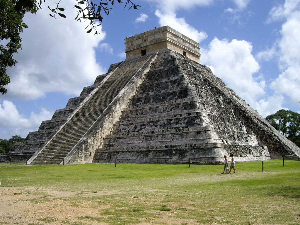 Stunning El Castillo Pyramid Wallpaper with Two Tourists in Mexico