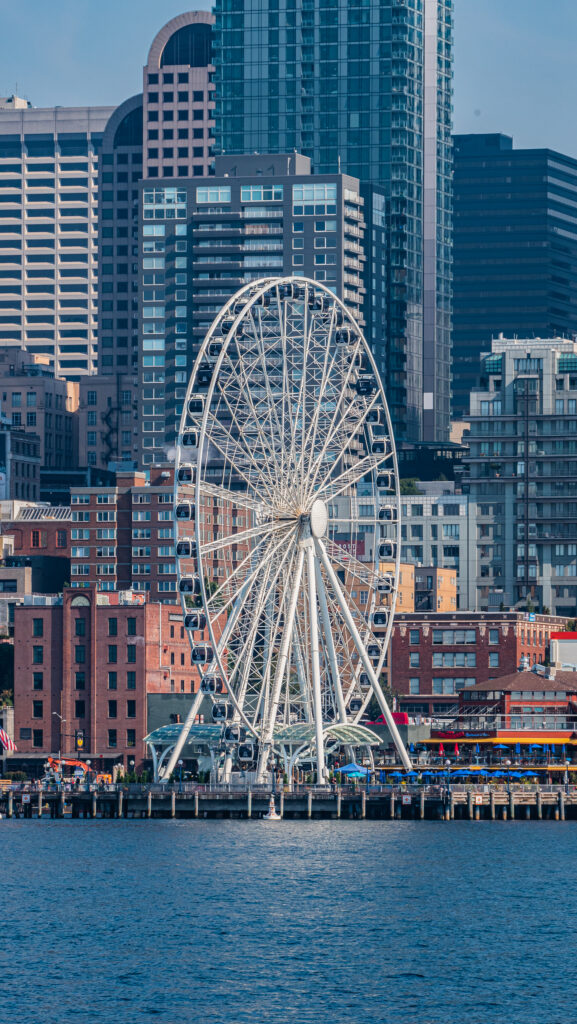 Scenic Ferris Wheel Wallpaper: Urban Waterfront Charm Background