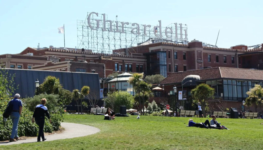 Ghirardelli Square Scenic View: Lush Garden, Iconic Brick Architecture Wallpaper