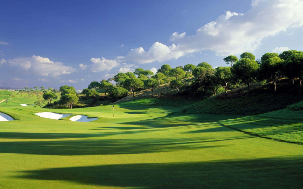 Serene Golf Course Wallpaper: Green Fairways & Blue Sky Background