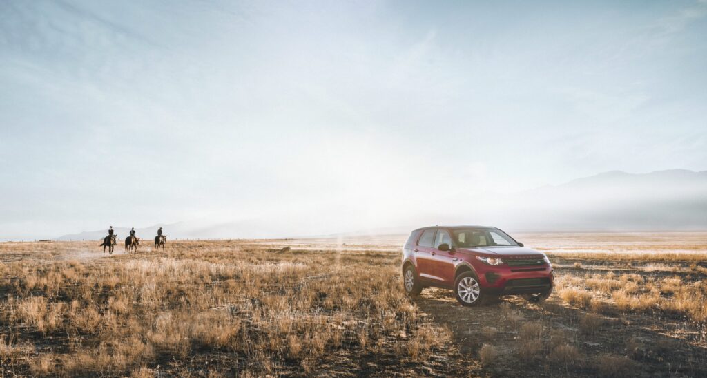 Land Rover Discovery in Sunlit Field - Scenic Adventure Wallpaper