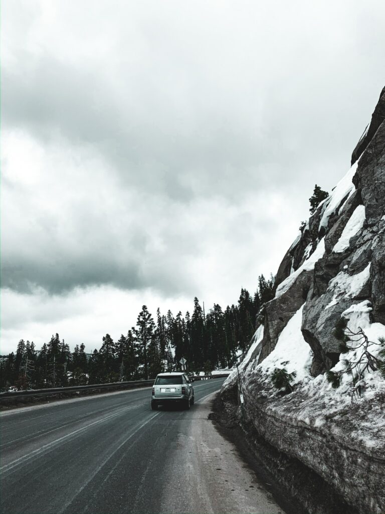 Land Rover SUV Adventure: Scenic Road Through Snowy Rocky Terrain Wallpaper