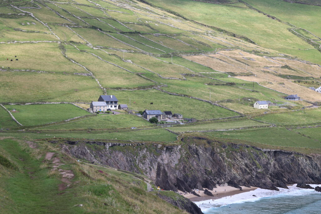Scenic rural landscape with grassy slopes cliff sandy beach and green rolling fields wallpaper background