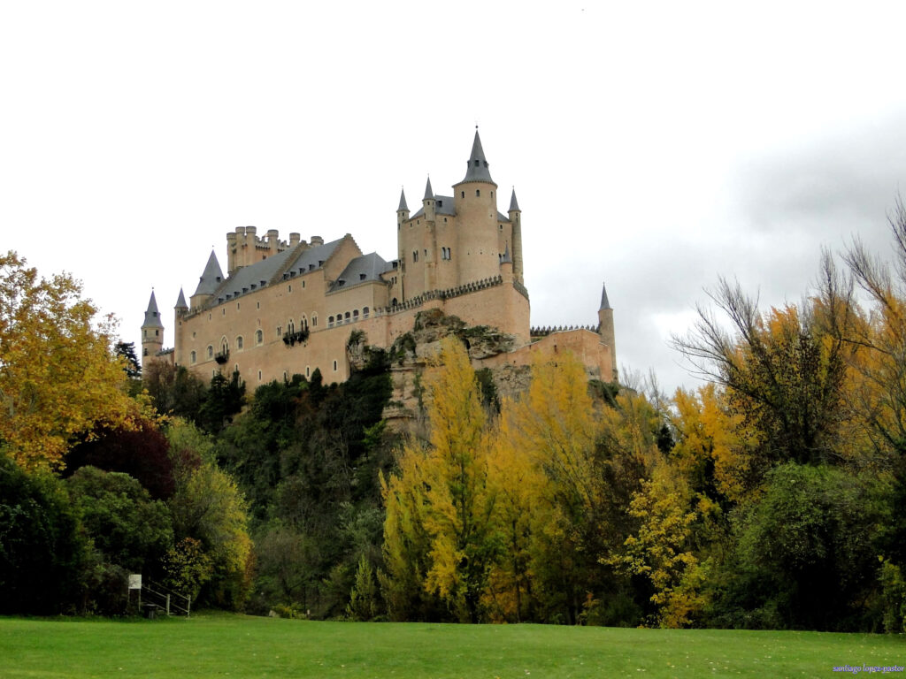 Segovia Castle Scenic Wallpaper: Lush Greens & Cloudy Sky Backdrop