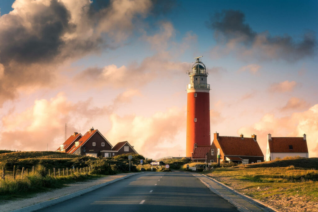 Scenic Texel Lighthouse View: Charming Houses & Vibrant Sky Wallpaper