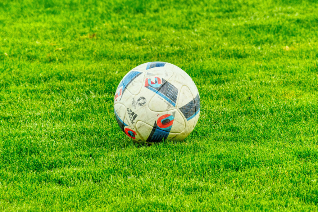 Close-up of Adidas Beau Jeu soccer ball on green pitch UEFA Euro 2016 vibrant wallpaper background